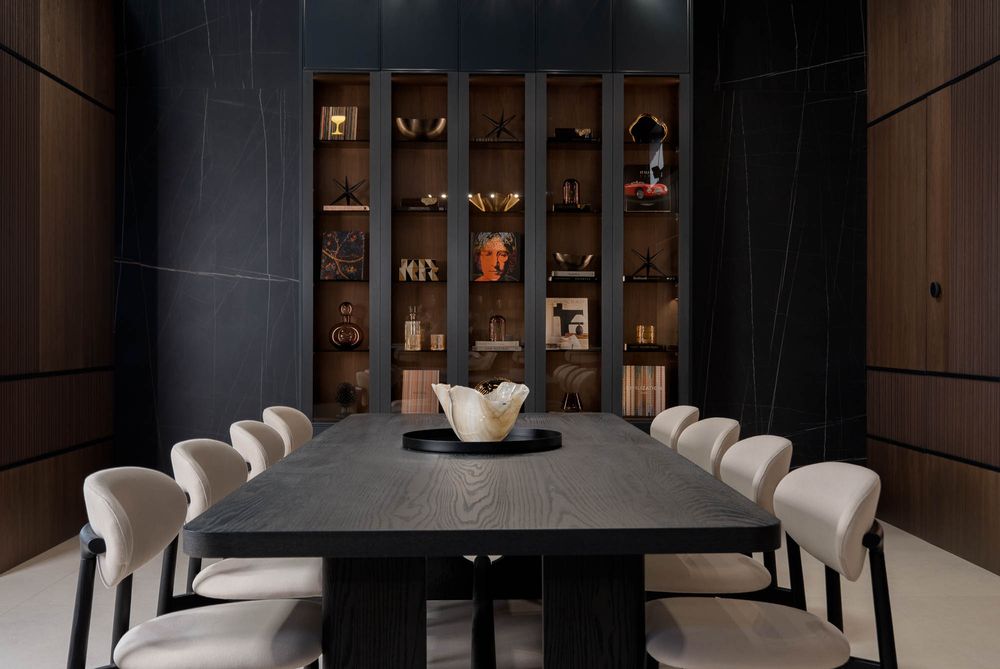 Luxurious dining room featuring dark wood walls, elegant table, and plush cream-colored chairs.