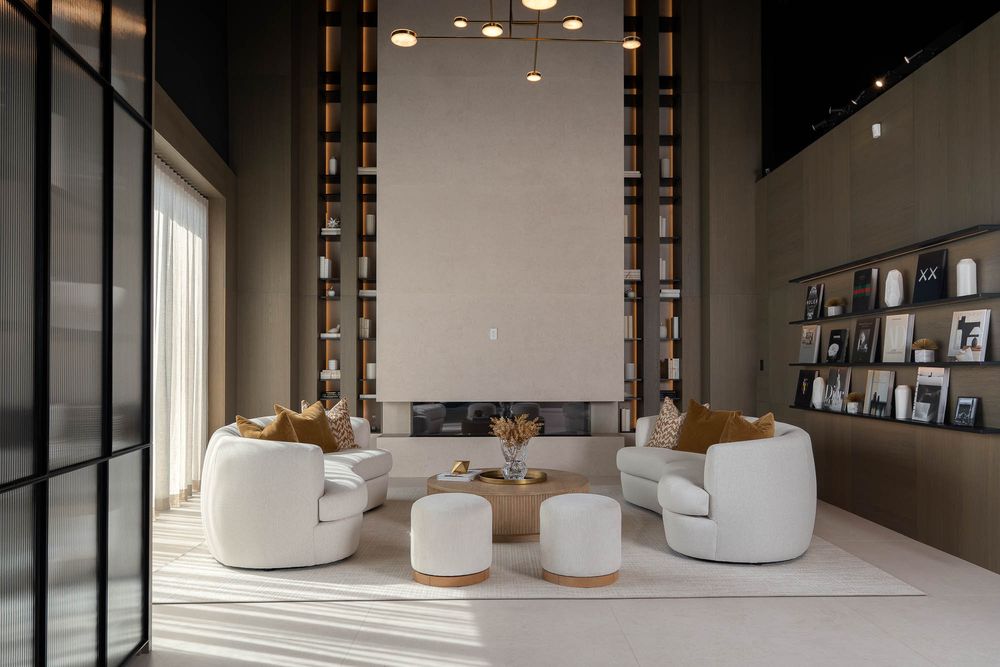 Modern open concept living room features sleek white walls, pendant lighting, and minimalist decor with panoramic views.
