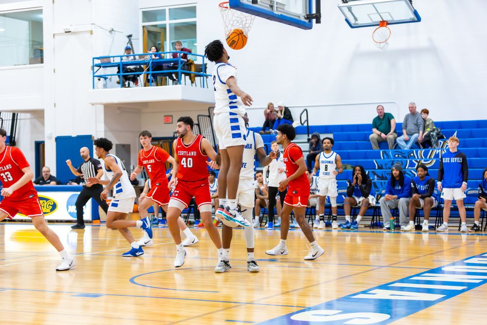 Wide view of a basketball game showing players spread across the court during active play.