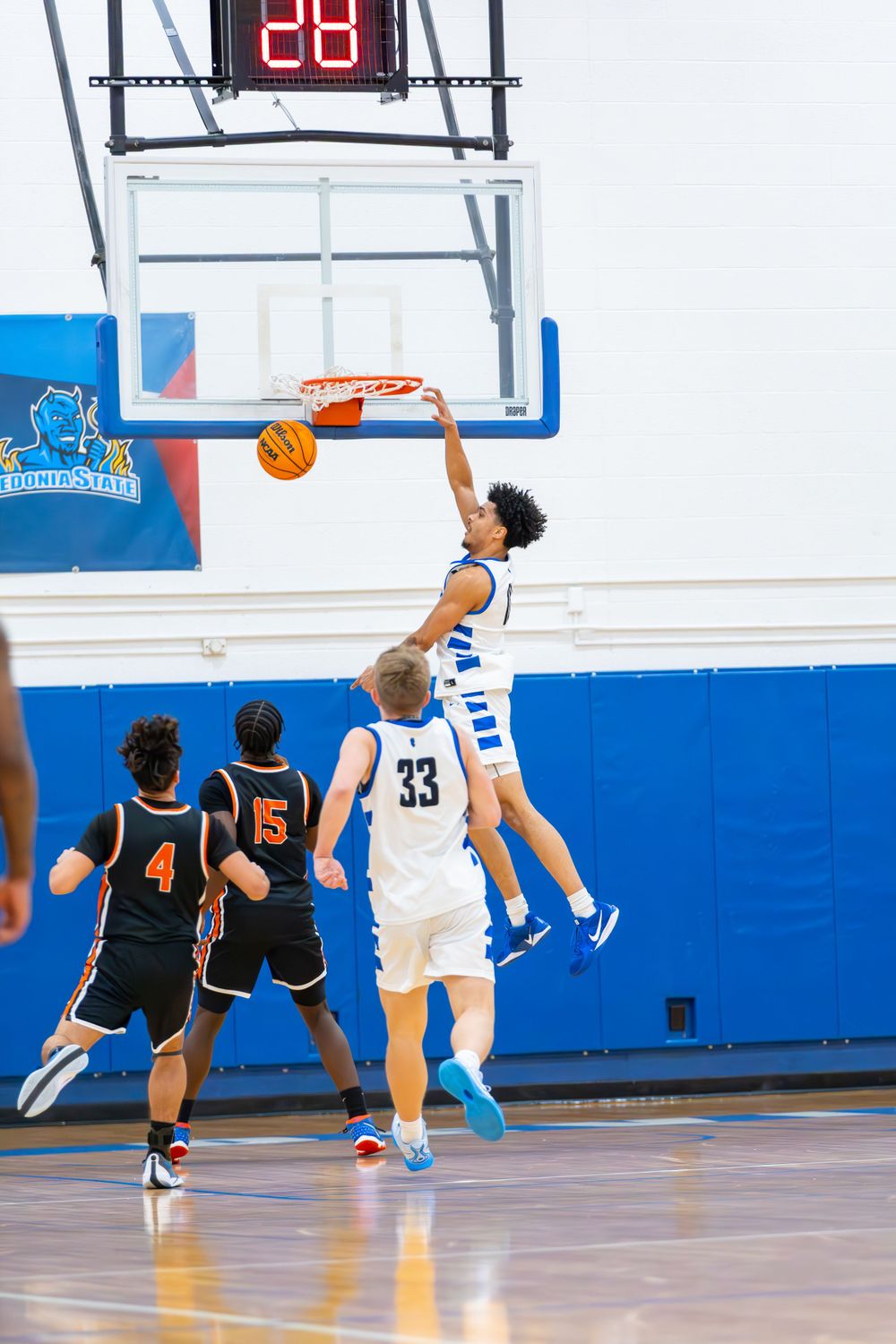 Players from opposing teams compete for a shot near the basketball hoop.