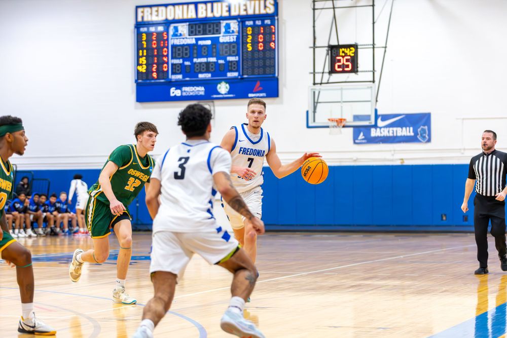 Basketball players from opposing teams move across the court during an intense game.
