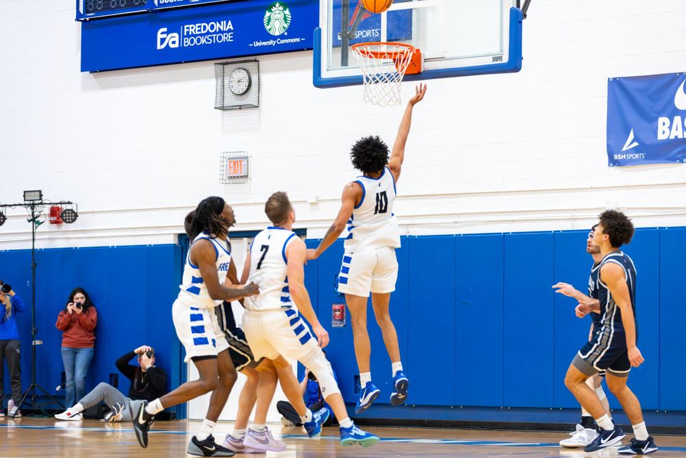Wide angle shot of basketball players in motion during a competitive game.