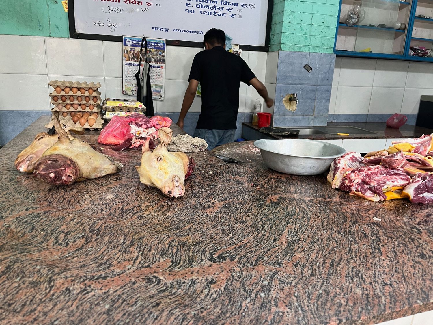 Outdoor market or butcher shop area with raw meat displayed.