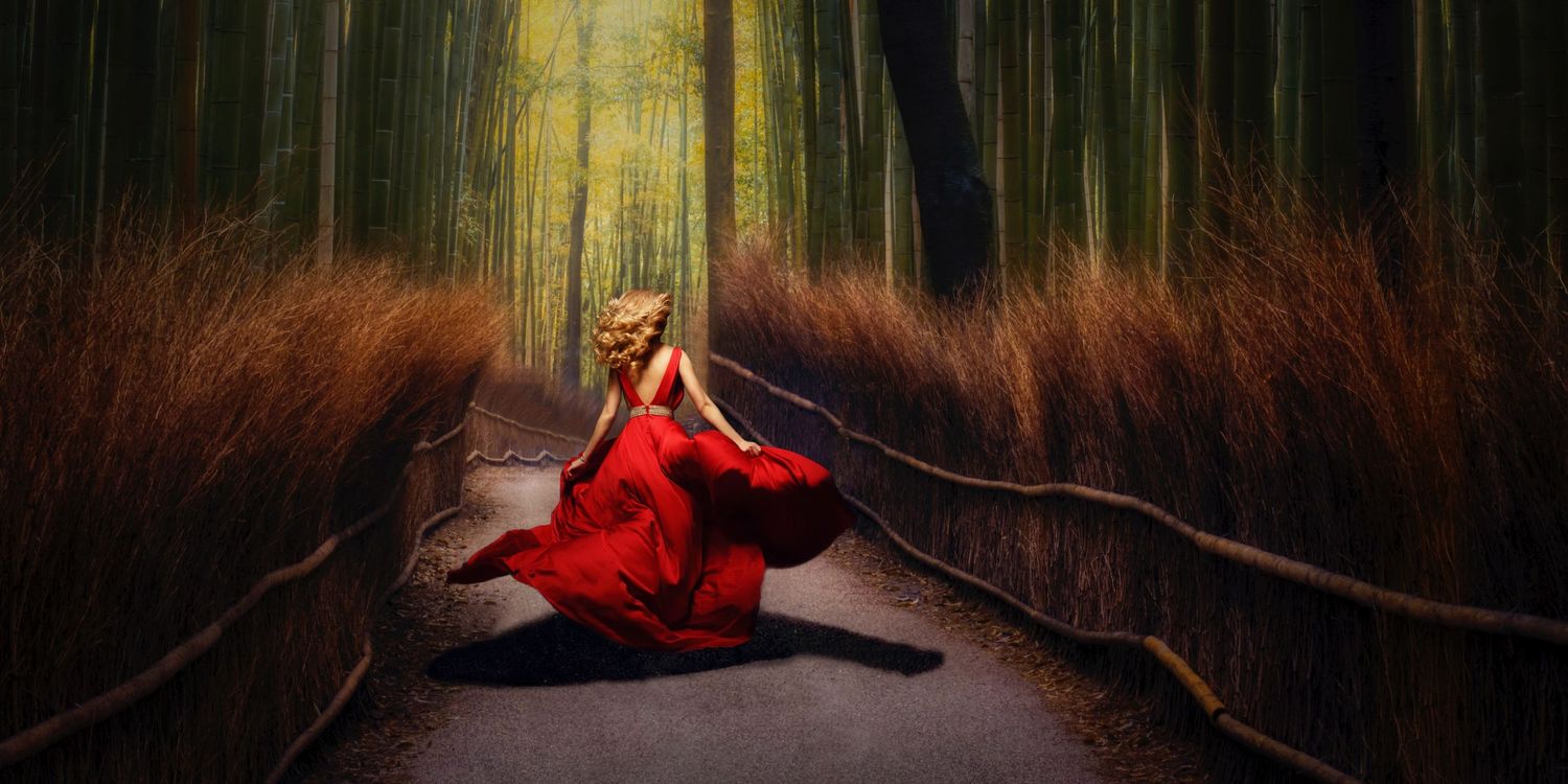 A figure in a flowing red dress walks along a forest path surrounded by tall trees in dreamy atmospheric lighting in a bamboo grove in Japan
