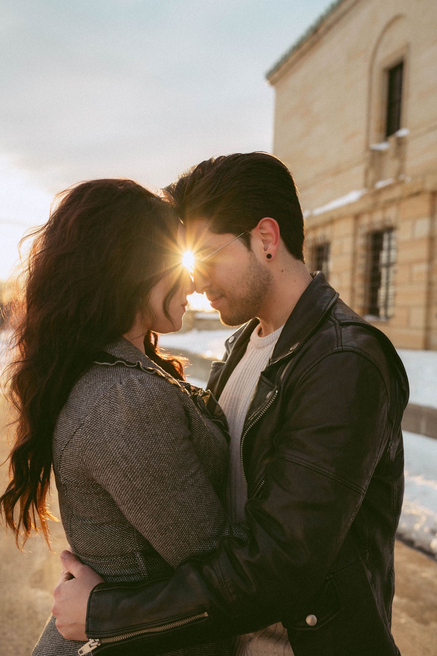 An engagement photo session at Dayton Art Institute in Dayton Ohio, in winter with snow on the ground during golden hour sunset.