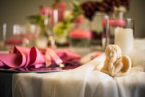 Wedding reception table details with soft focus on pink and white decorative elements.