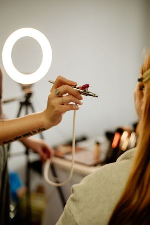 Ring light reflection creates circular highlights during wedding preparation.