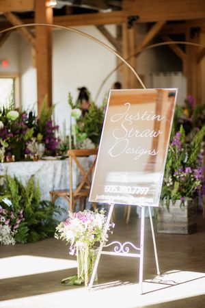 Elegant wedding signage displayed with fresh floral arrangements in natural light.