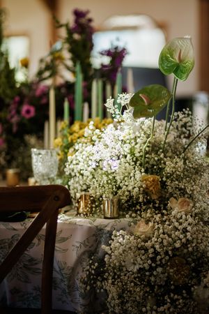 Delicate white baby's breath flowers arranged in rustic wedding reception decor.
