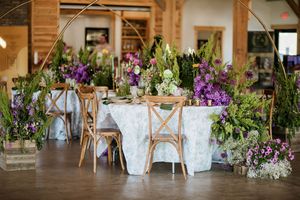 Elegant wedding venue interior decorated with purple and white floral arrangements.