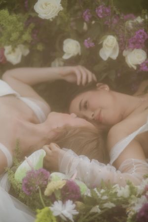 Dreamy garden scene with white roses and purple flowers in soft natural light.