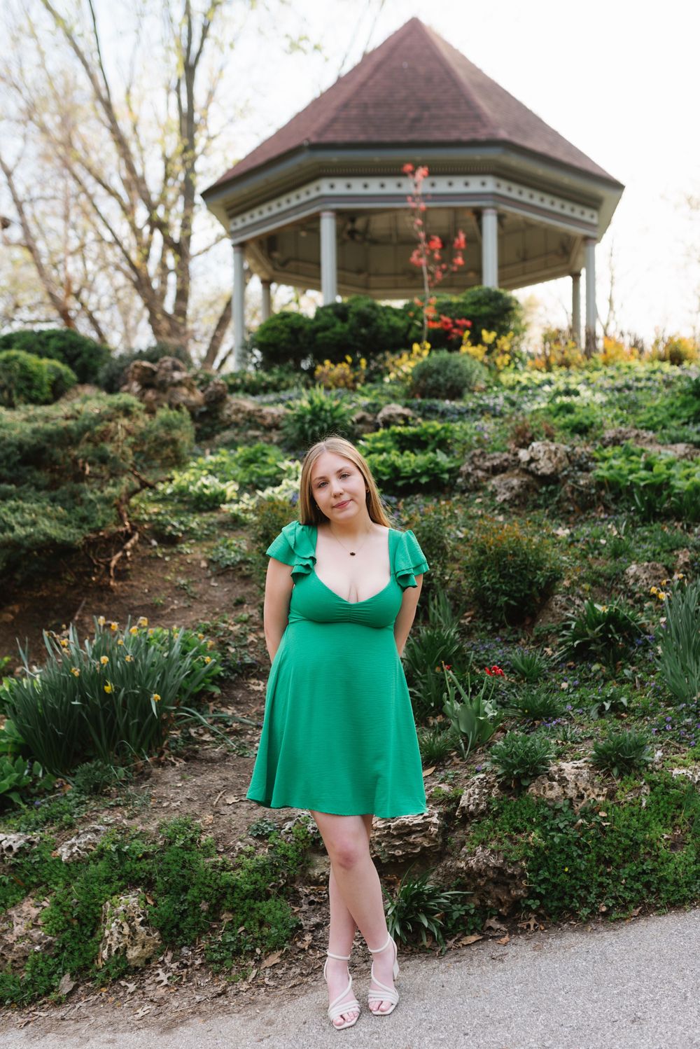 Green floral garden setting with tulips and outdoor gazebo structures creating a springtime atmosphere.