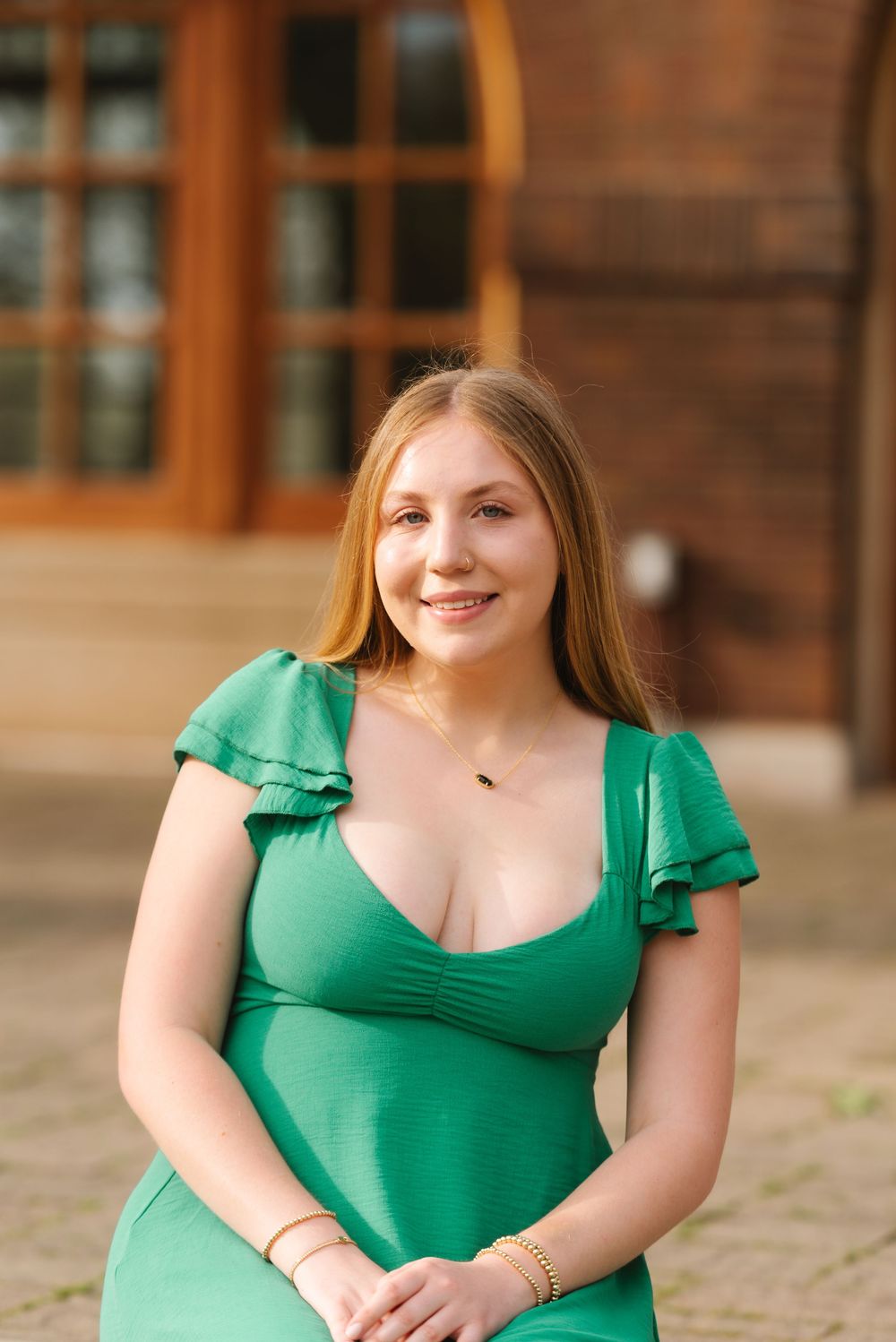 Green dress photographed against rustic wooden building with warm lighting.