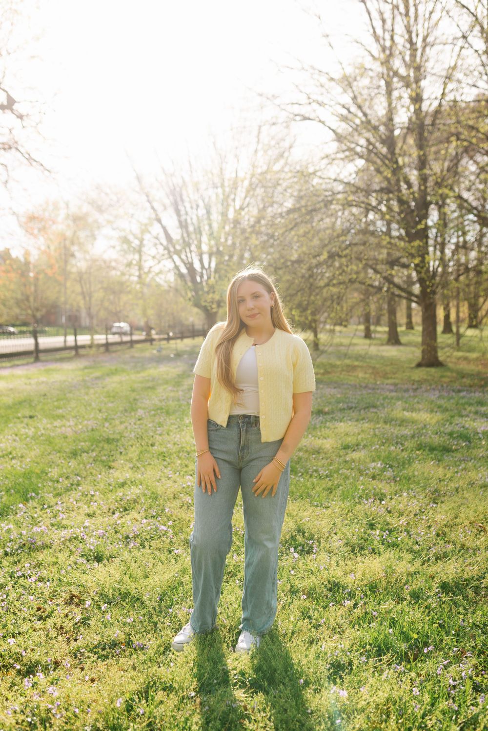 Sunny spring day fashion shoot in grassy park setting with trees in background.