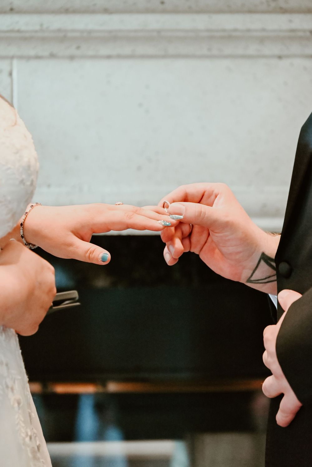 Close-up shot of a wedding ceremony as a ring is being placed on a finger during the exchange of rings.