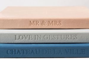 Book spines arranged horizontally show neutral-toned hardcover books with titles including 'Love in Gestures' and 'Chateau de la Ville'.