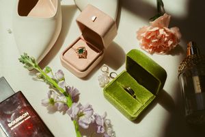 A series of modern geometric soap bars in green and beige tones arranged artfully with fresh flower petals and sprigs.
