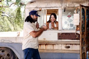 Rustic outdoor bar setting with wood beams and natural lighting for engagement photos.