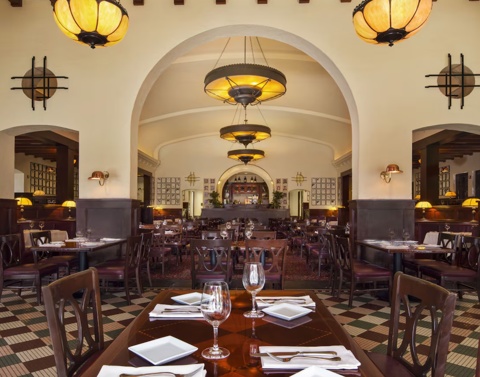 Elegant restaurant interior with arched ceiling, pendant lighting and traditional dining setup.