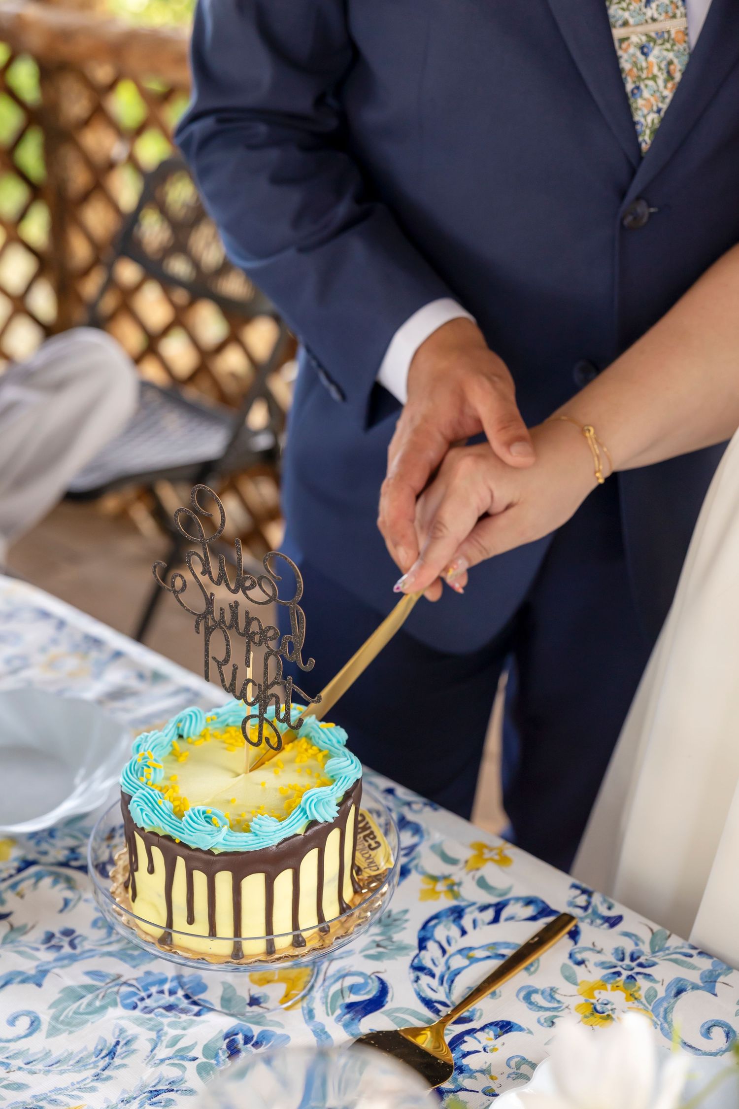 couples hands cutting small cake with topper that says "because 2 people swiped right"