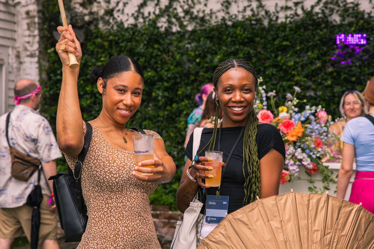 Group enjoying drinks and socializing at an outdoor gathering wearing summer attire.