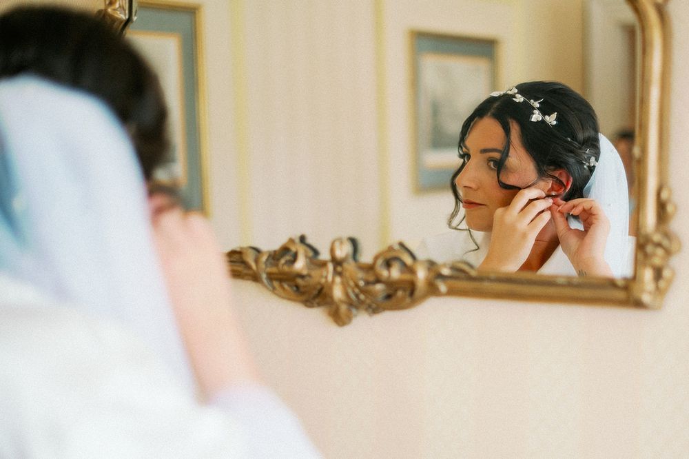 Elegant gold-framed mirror reflecting wedding day preparations.