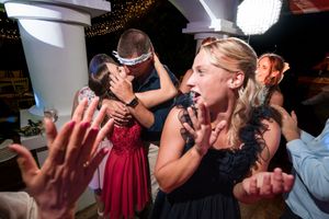 Guests dancing and celebrating joyfully at a wedding reception party indoors.