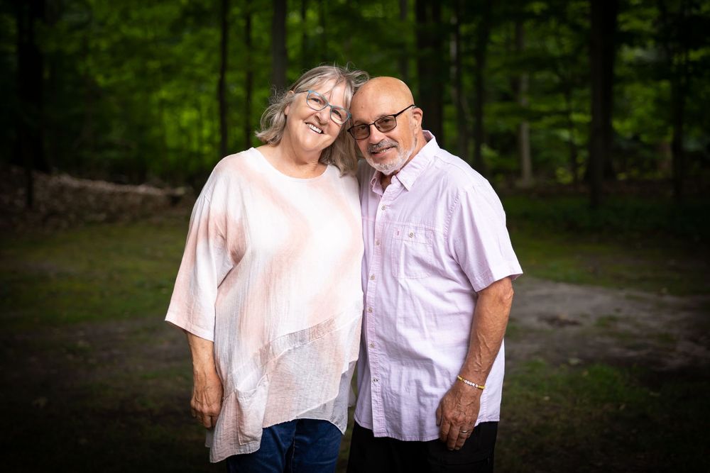 Family members hugging and smiling together in casual outdoor setting.