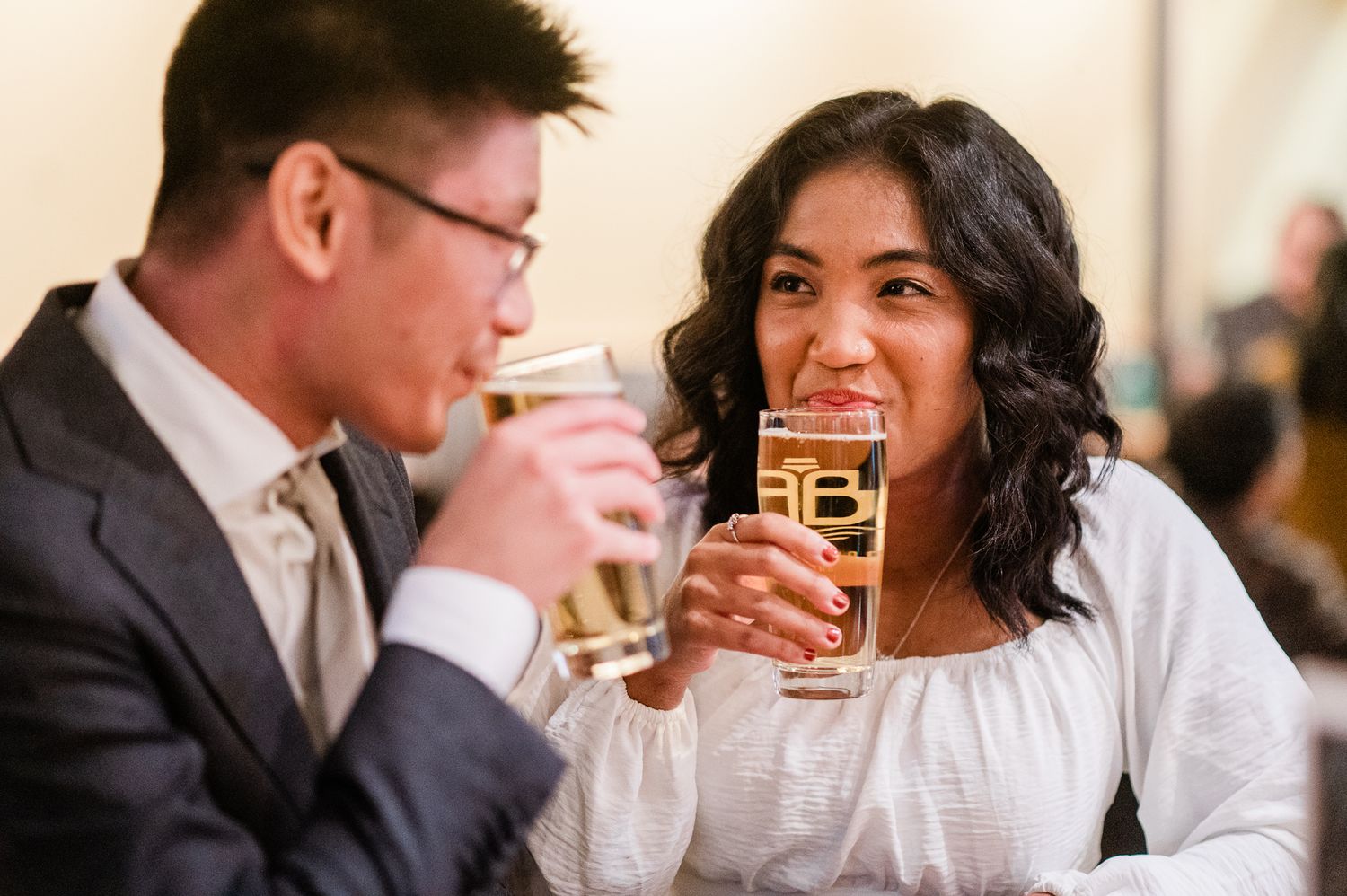Wedding guests clink glasses in celebration while toasting at an elegant reception