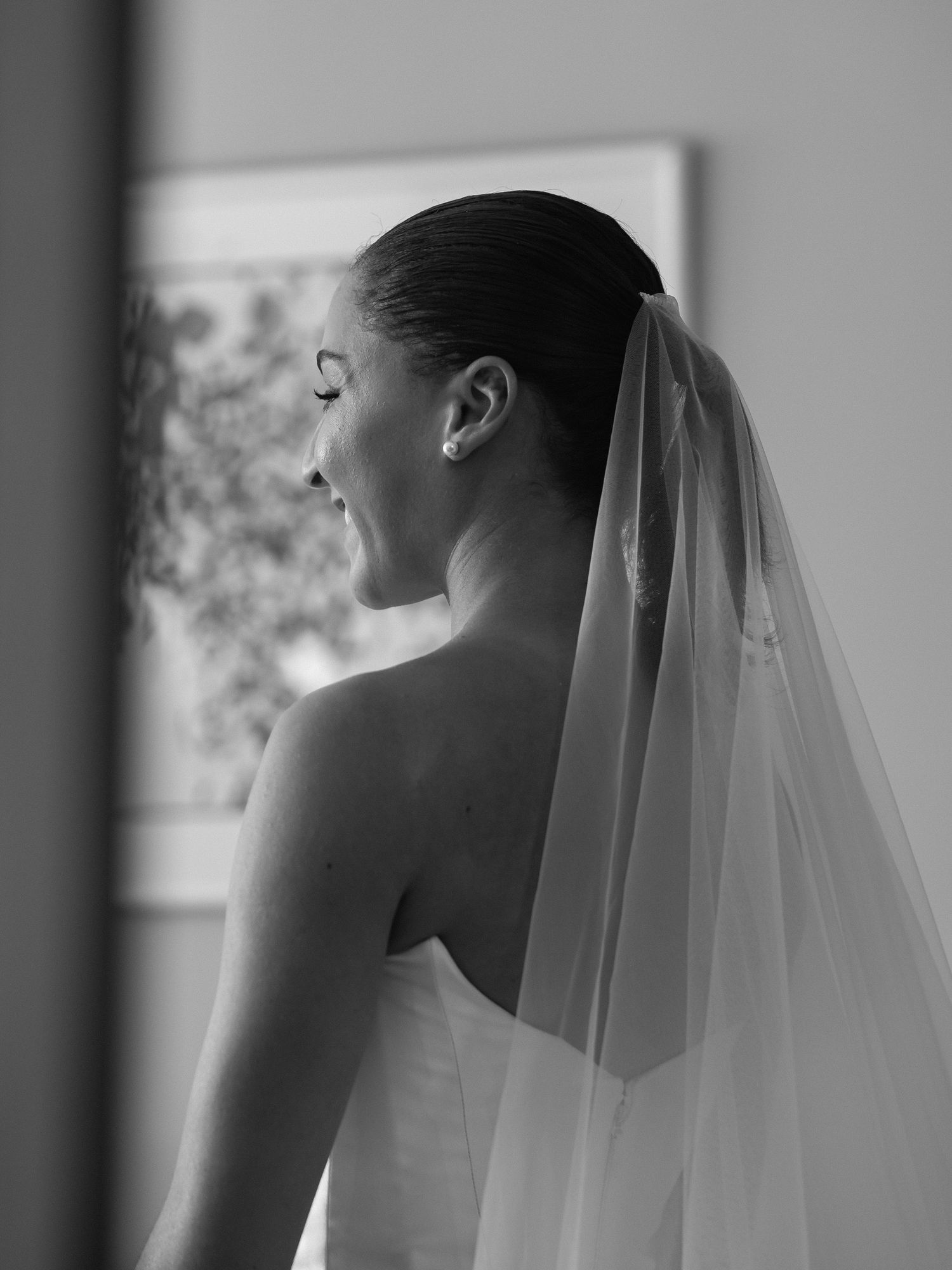 A silhouetted profile of someone wearing a wedding veil in black and white.