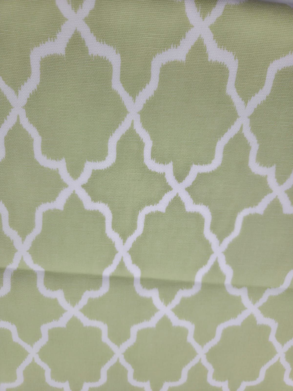 Seamless geometric trellis pattern in light sage green and white with Moroccan-inspired quatrefoil design.