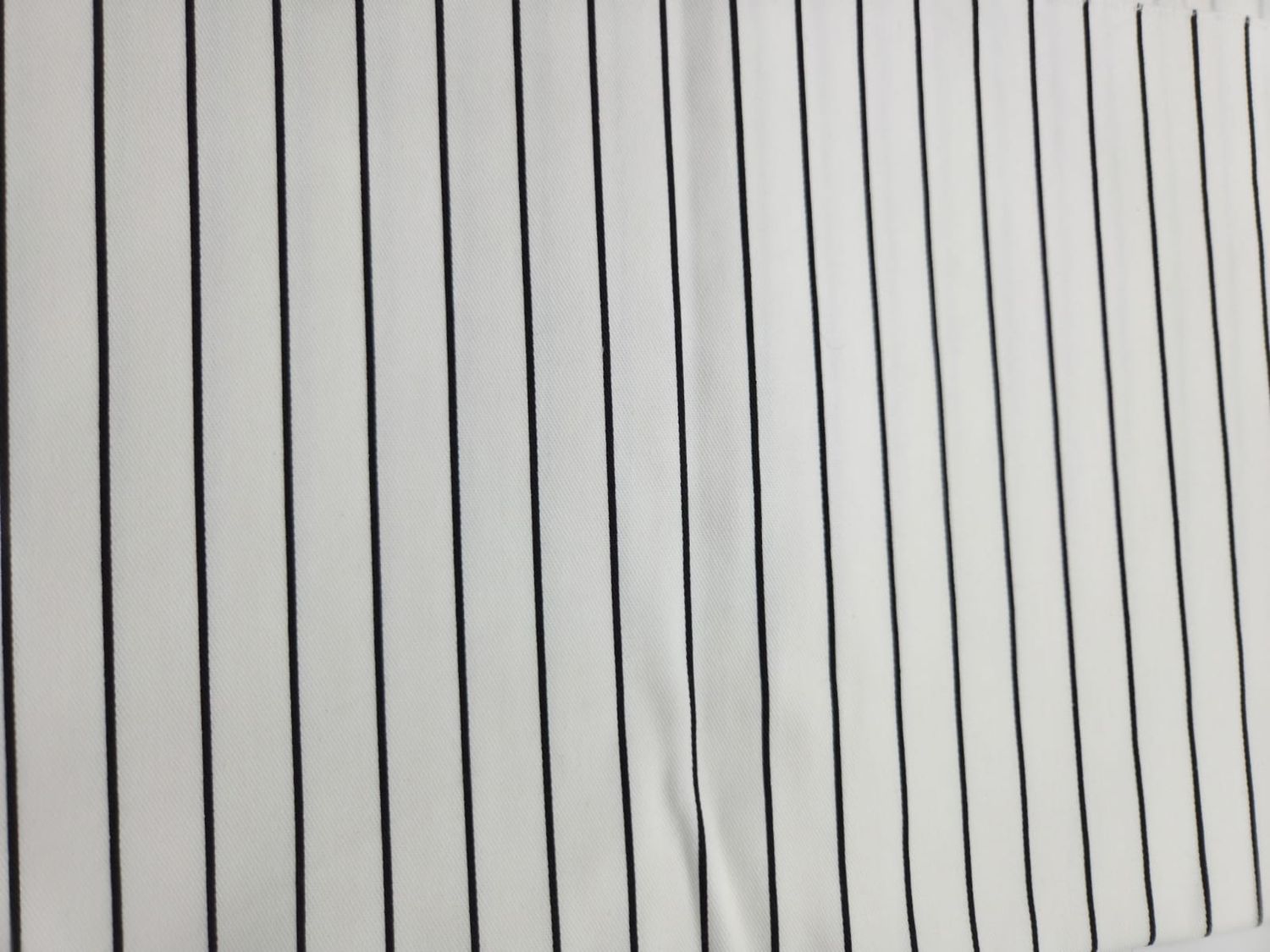 Thin black vertical pinstripes arranged in parallel lines on a light gray background.