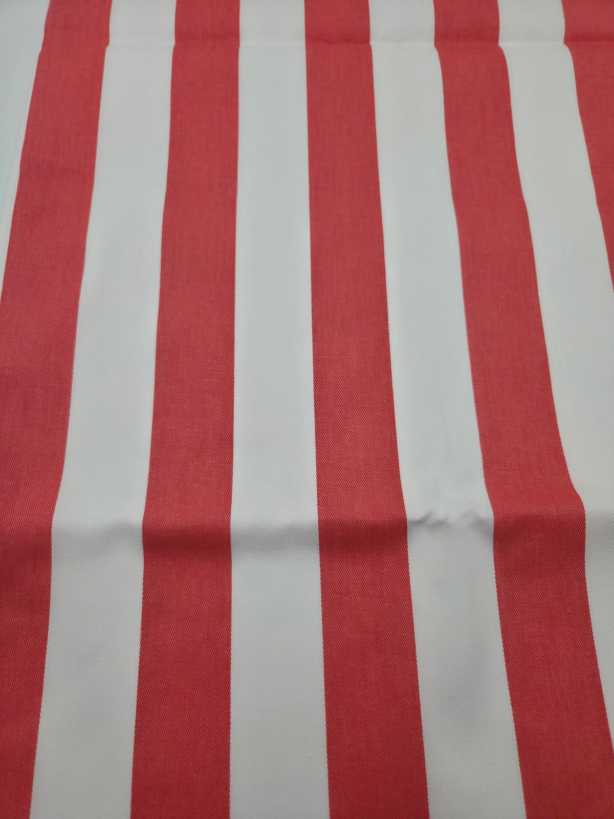 Red and white vertical striped fabric pattern with bold contrasting colors.