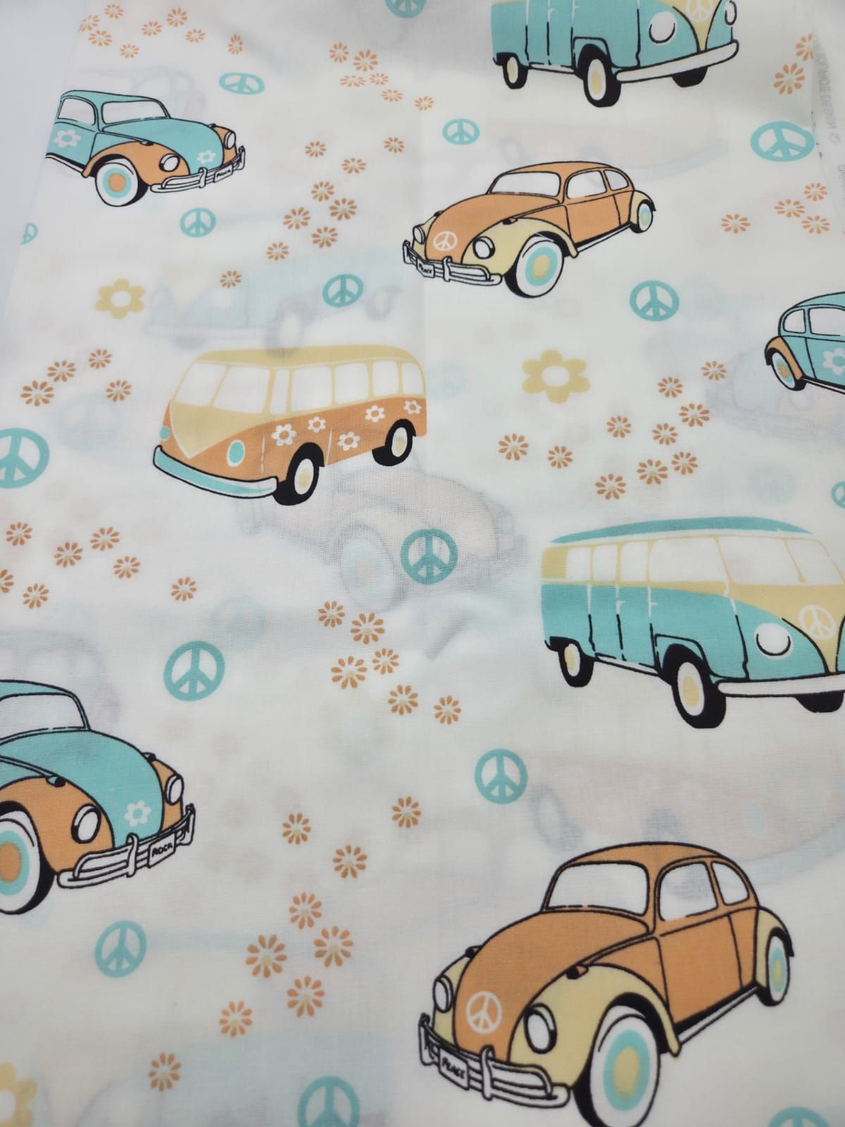 Retro pattern fabric featuring vintage Volkswagen Beetles and vans in soft blue and tan colors with peace signs and flowers.