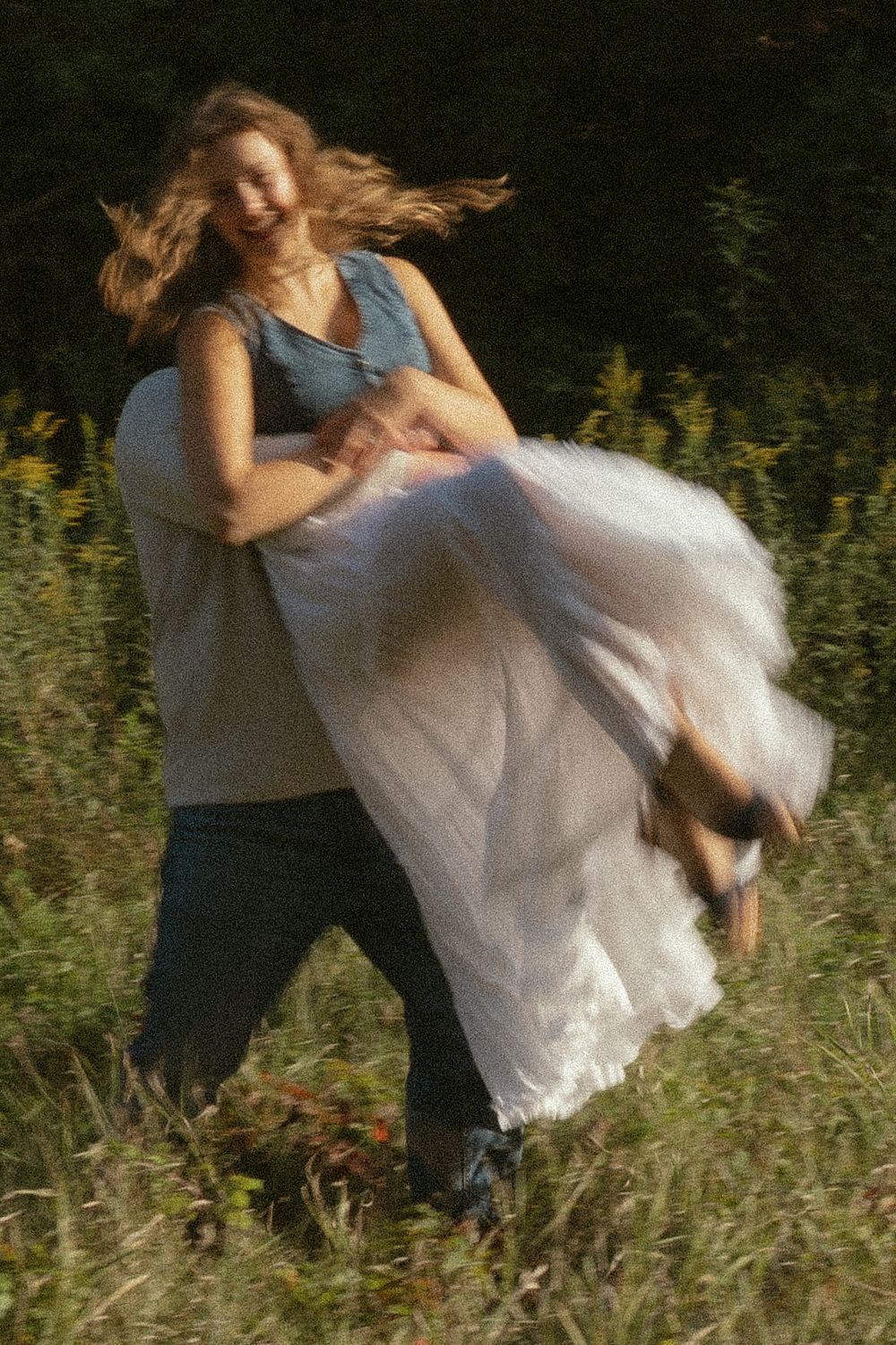 A playful dance dip moment captured in a field of wildflowers.