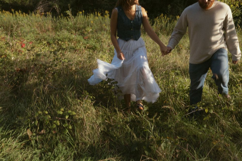 People posing and interacting in a sunny meadow during a photo session.