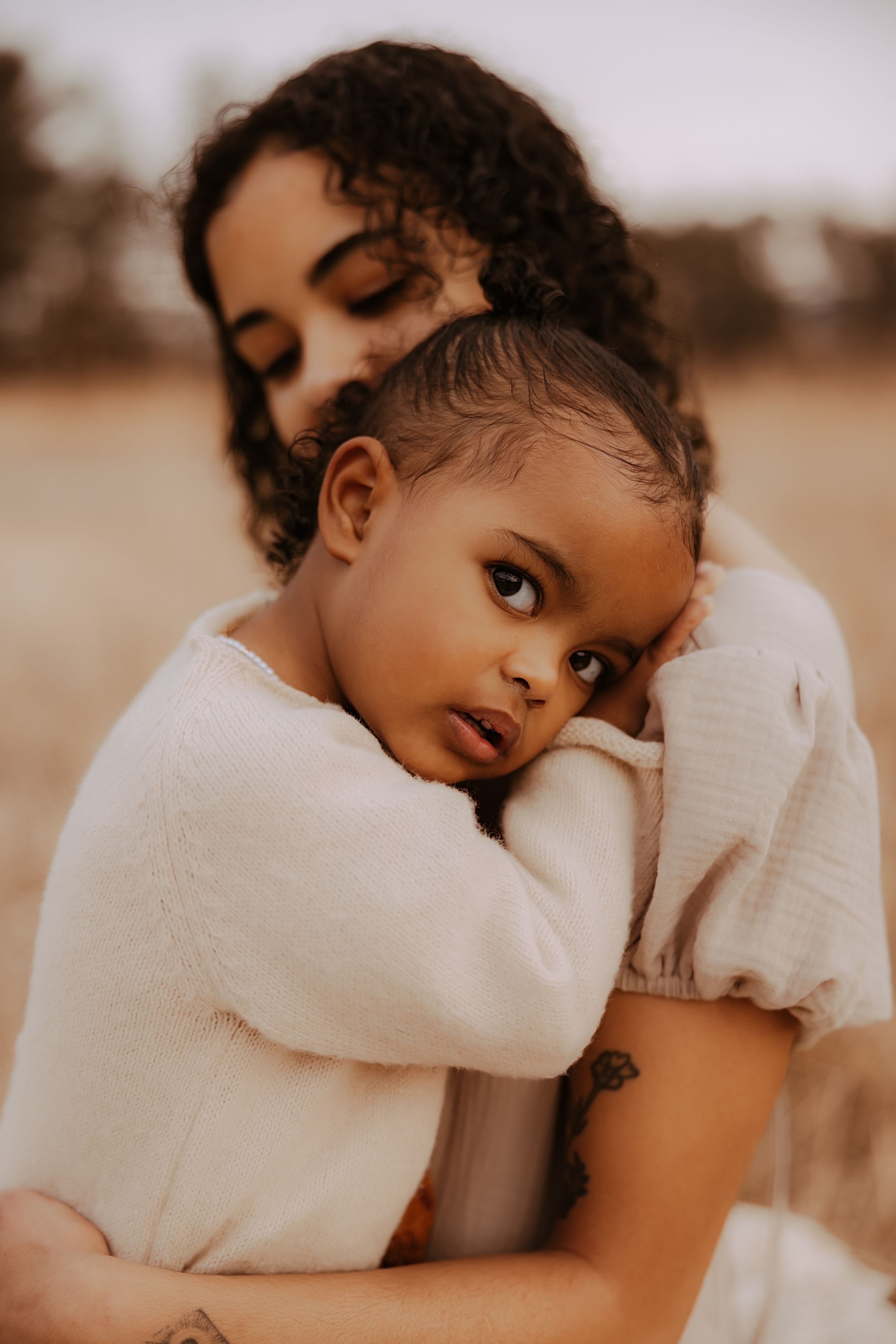 A series of warm-toned photographs showing tender moments between a parent and young child in soft lighting.