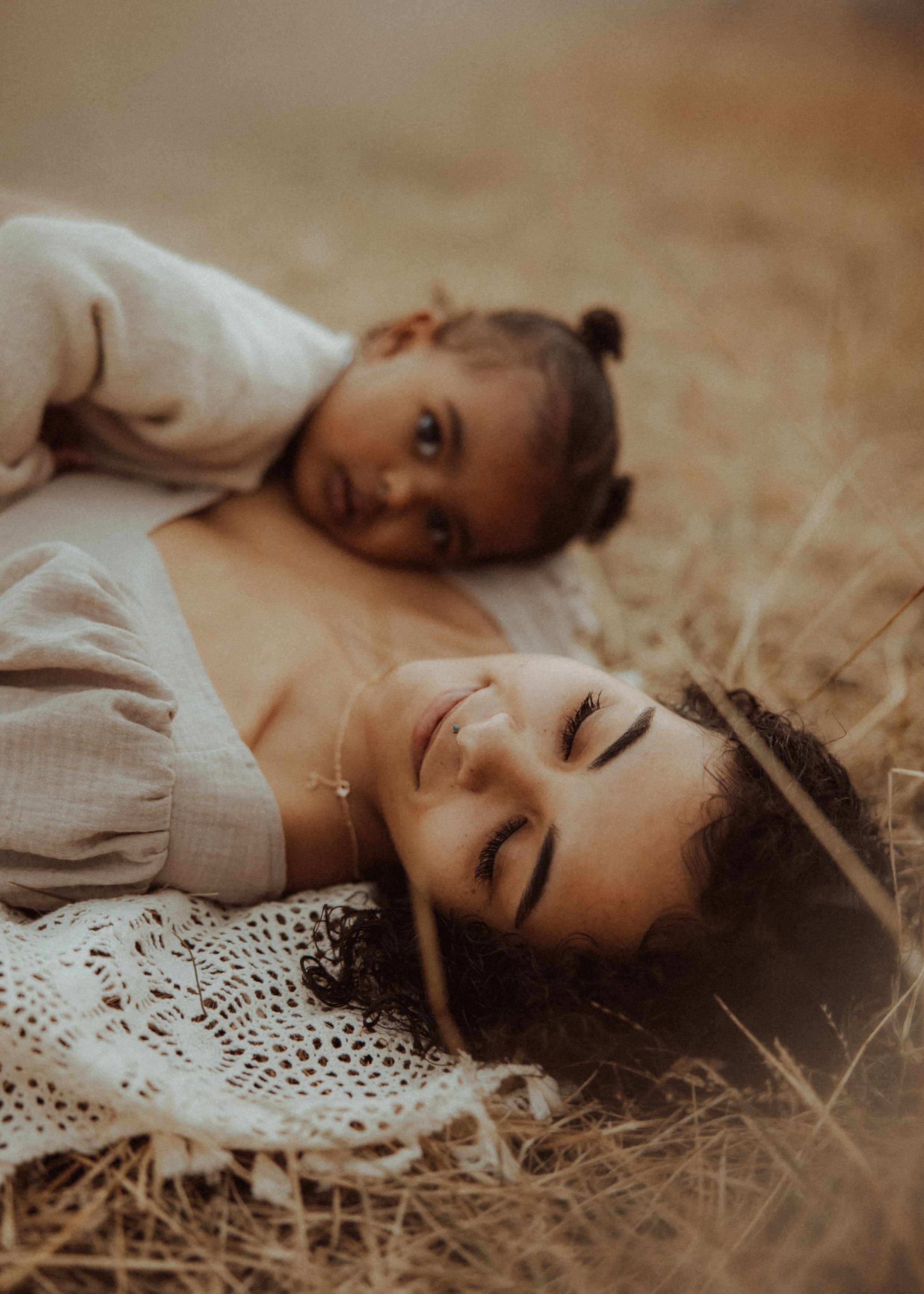 Dreamy portrait sequence showing someone lying in a field wearing white lace against a soft sepia background.