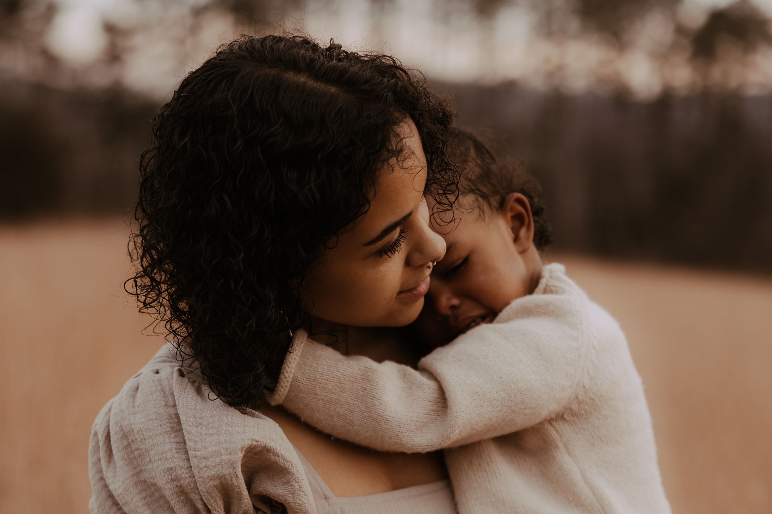 A tender moment captured in warm sepia tones showing affection and connection between two people.