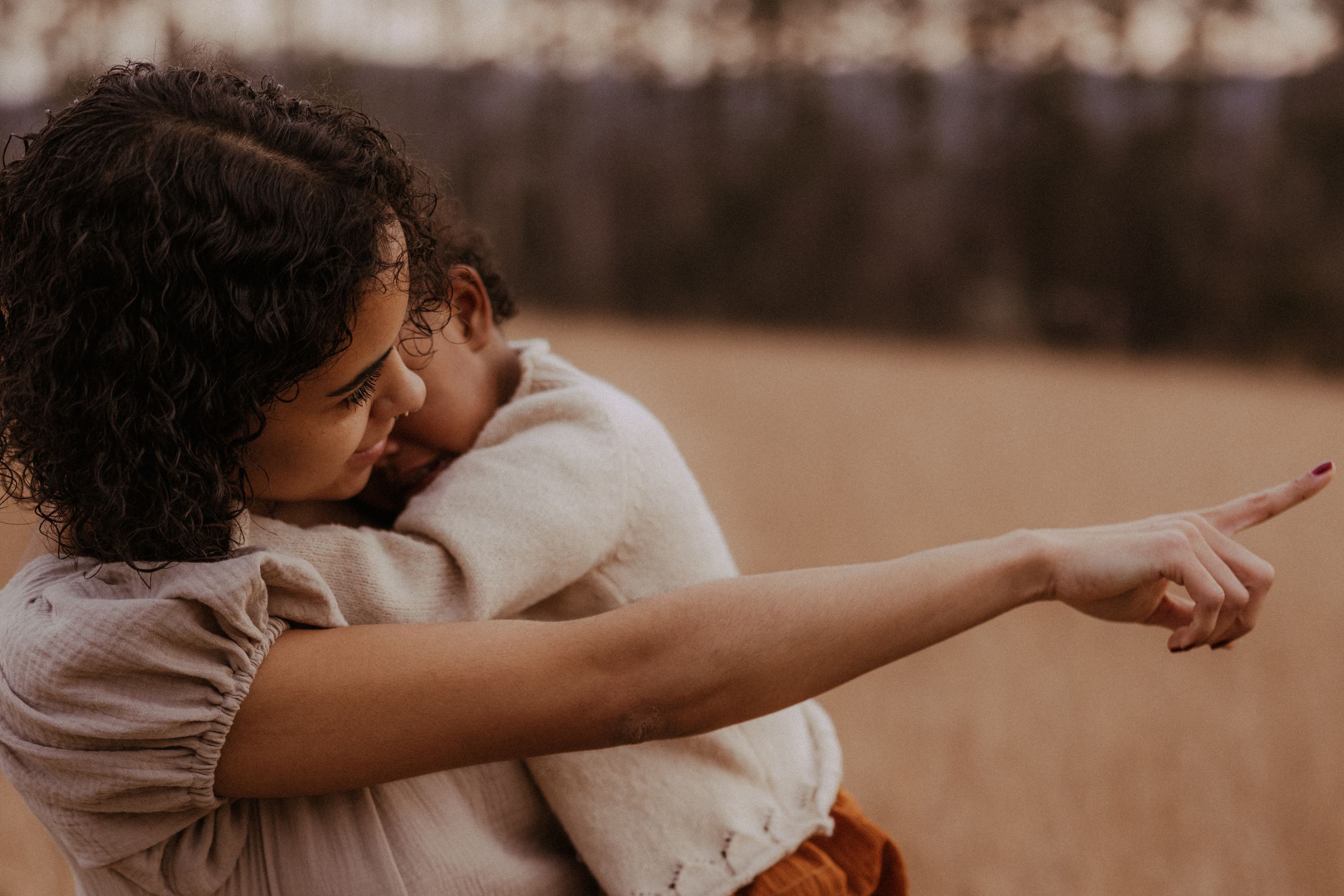 A couple embraces tenderly in a warm sepia-toned outdoor setting.