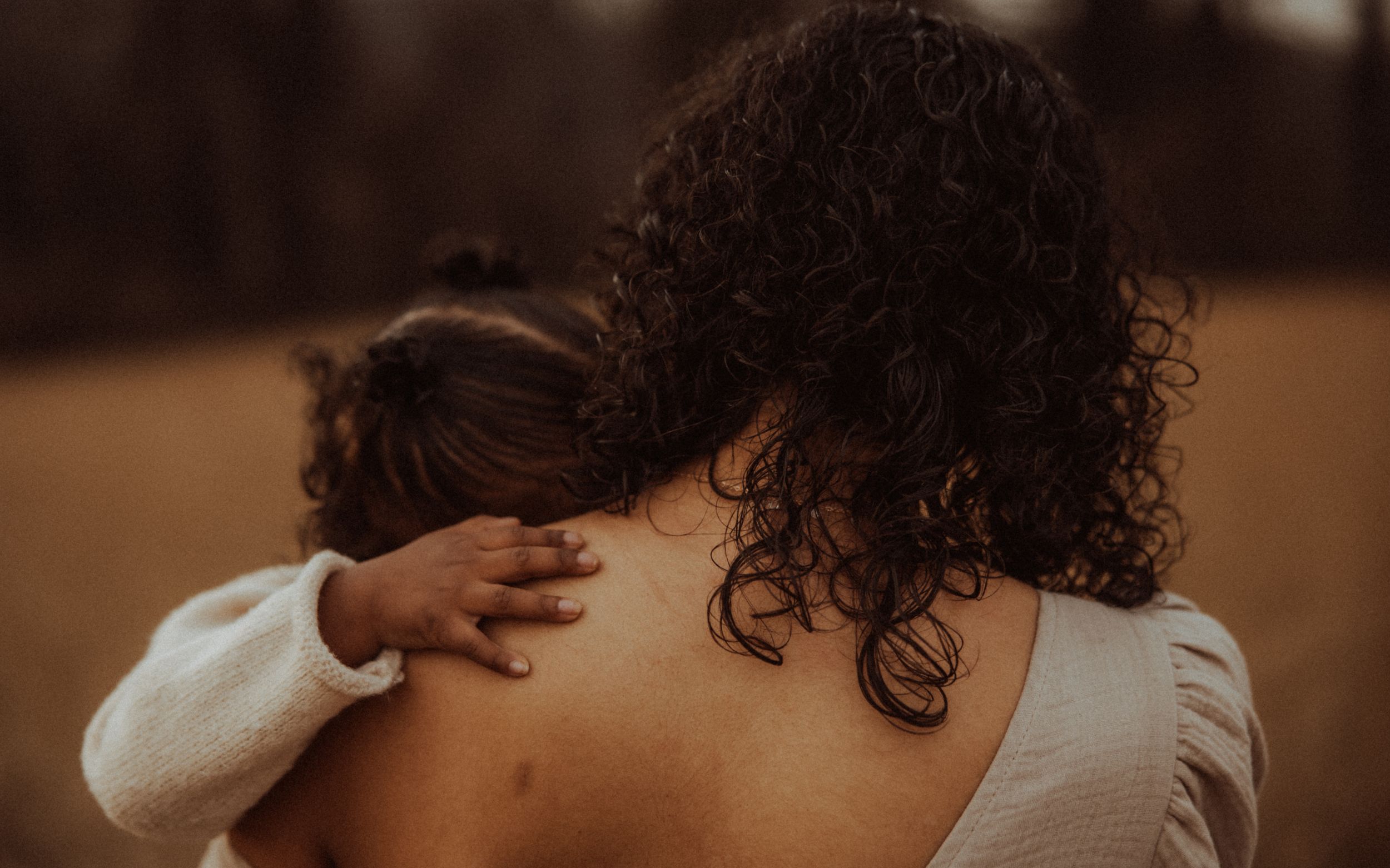 A romantic couple embraces in warm lighting while sharing an intimate moment together.