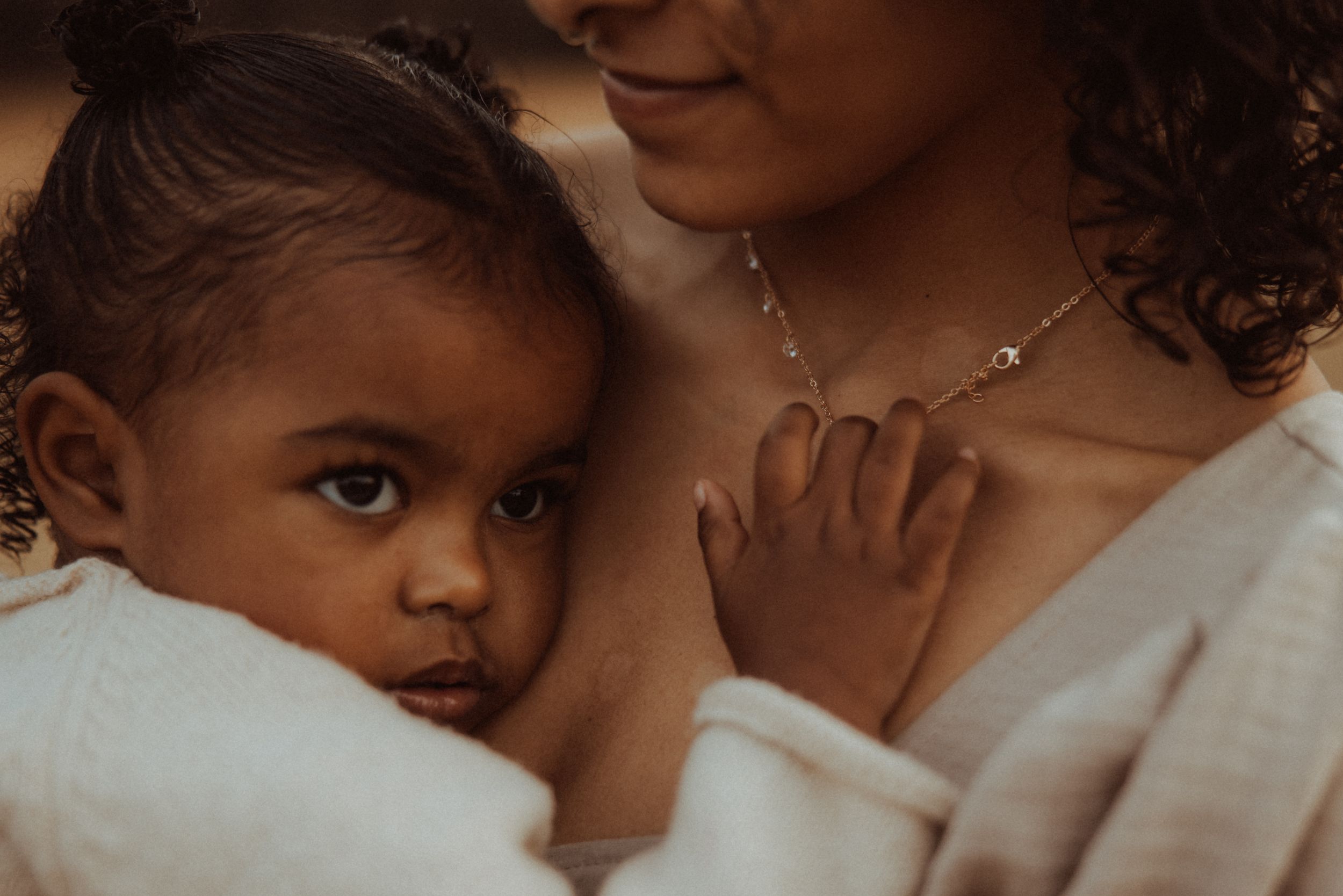 A series of intimate photos showing tender moments between a parent and child in warm, natural lighting.