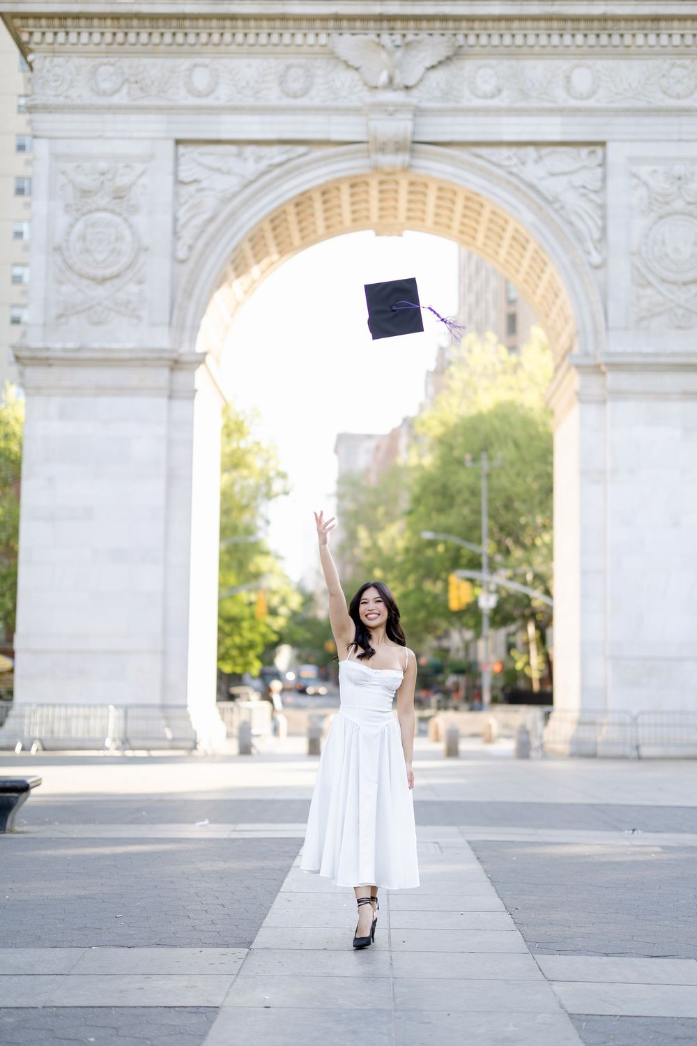 A series of graduation photos taken at Washington Square Park with the iconic arch monument in the background.
