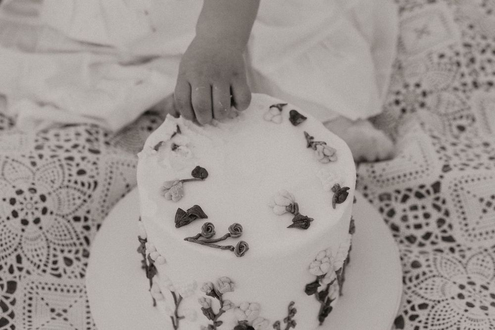 Vintage black and white photograph showing cookies and baked goods arranged on a decorative lace tablecloth.