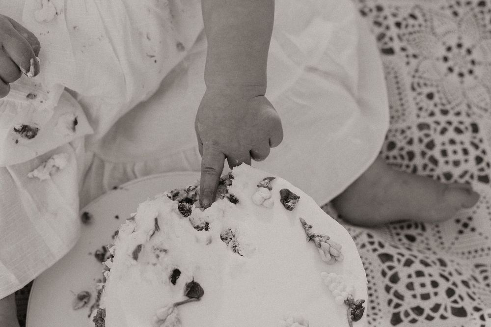 A black and white close-up photograph shows delicate white rose petals with dark spots creating an artistic pattern.