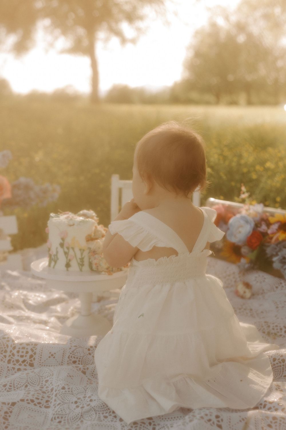 Sunlit outdoor scene with white fabric and lace details against a golden hour background.