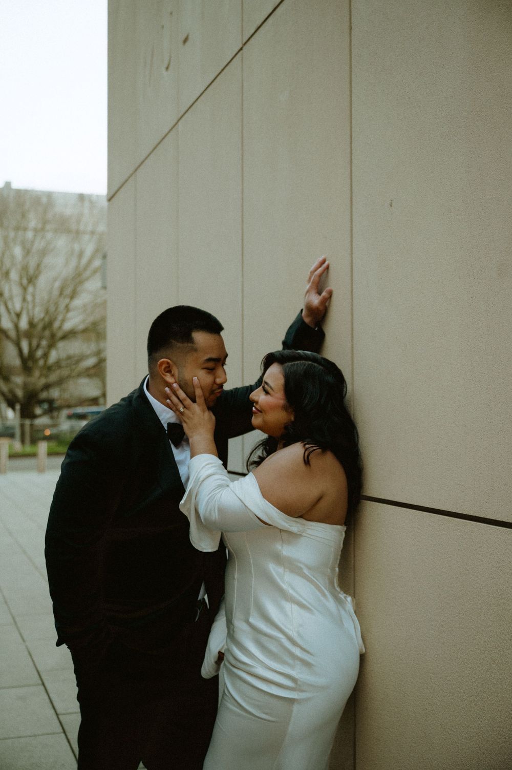 Intimate black and white photo series showing tender moments against concrete wall.