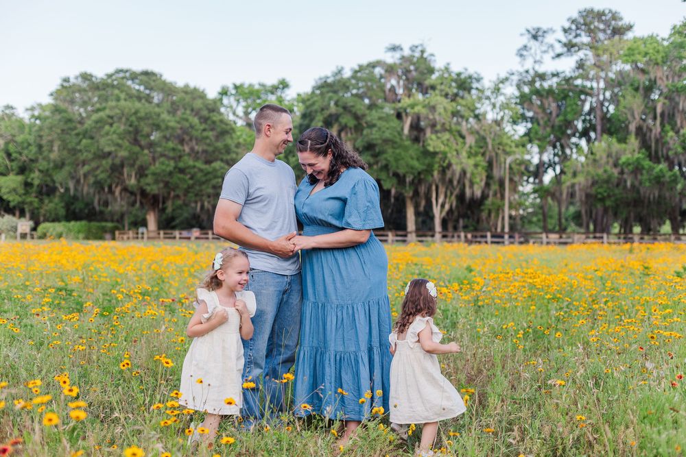 Family enjoying a sunny afternoon in a vibrant yellow wildflower field during springtime.