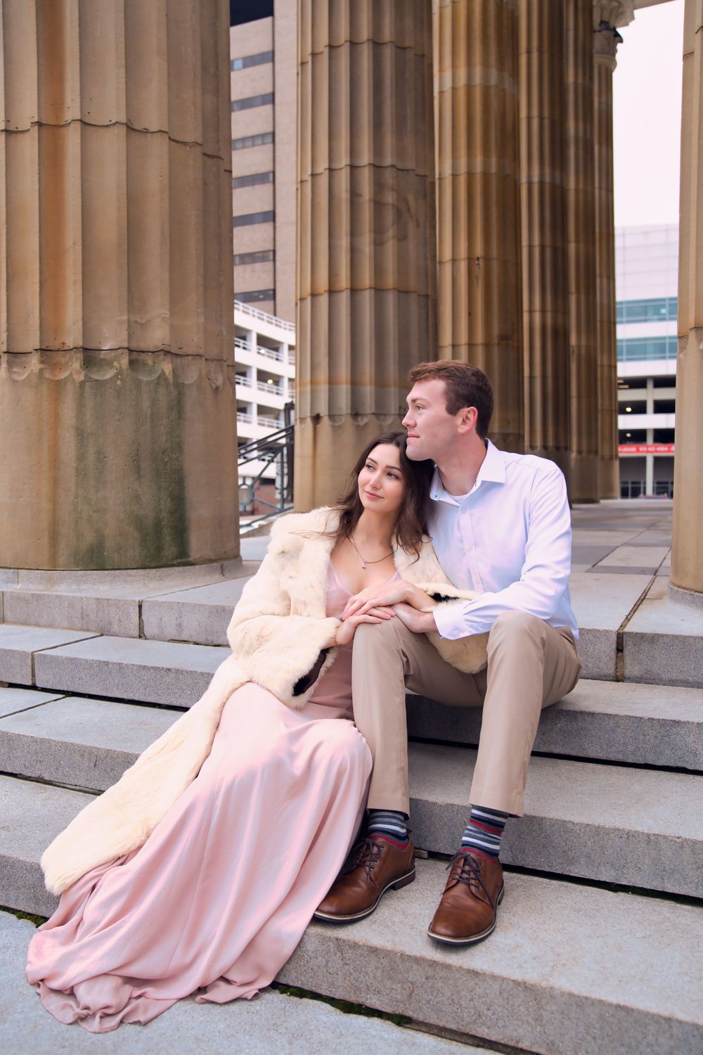 Downtown engagement locations for couples at downtown Cincinnati. Couple sitting by large colomns: Cincinnati Wedding Photographer