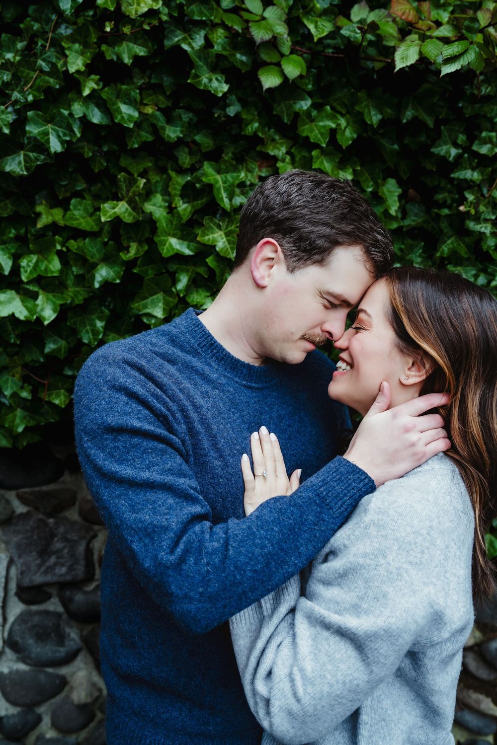 Romantic moment captured against lush green foliage backdrop.